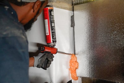 a groundworks tech filling gaps with new insulation