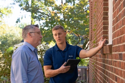 Baker's Waterproofing inspector meeting with a homeowner