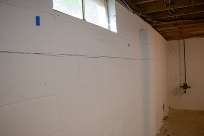 brick wall in a basement bowing inward and cracking