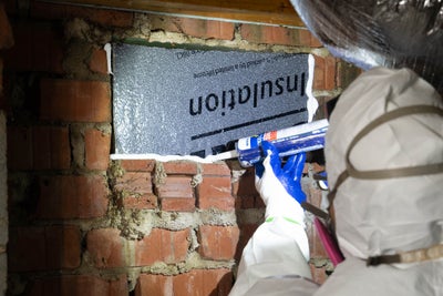 a worker seals a crawl space with insulation