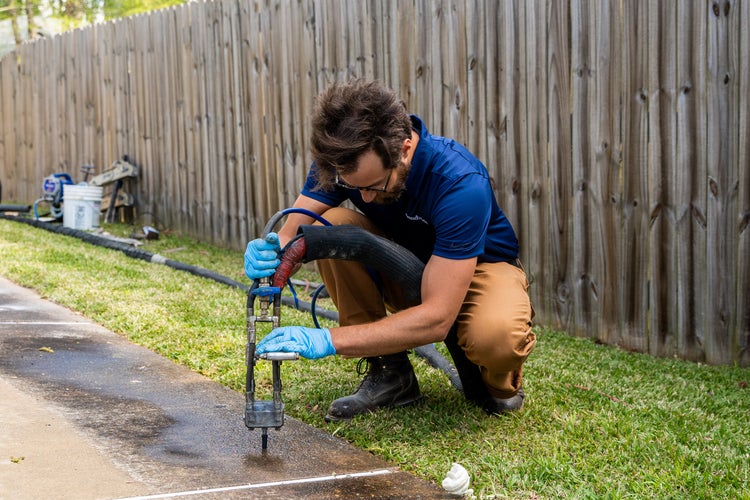A worker installing PolyRenewal in a concrete slab.
