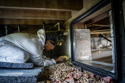 CFI tech installing a crawl space door inside crawl space of a home