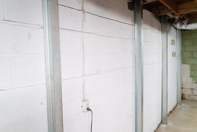 Steel I-beams attached to block walls in basement.