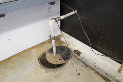 Old, failing sump pump in a basement