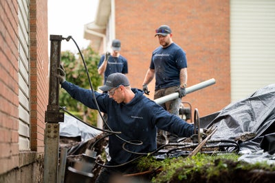 Professionals using piers to fix a foundation problem