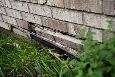 Uneven bricks on base of a home.
