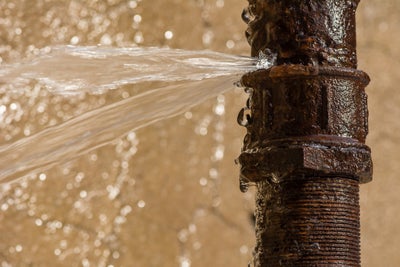 burst pipe spewing water