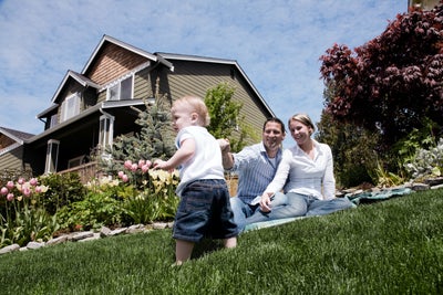 A happy family outside of their home, happy that they are safe from radon