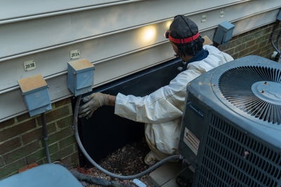 Man installing a crawl space door.