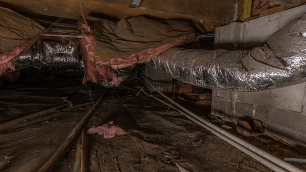 fiberglass insulation falling from the top of a crawl space