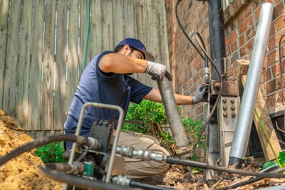 Groundworks crewman installing a foundation pier.