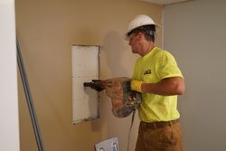 A worker installing wall anchors.