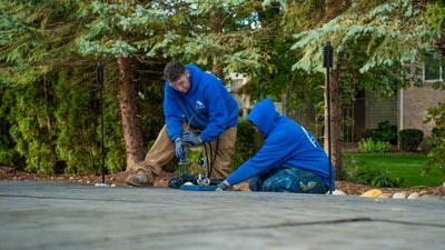 Two crewmen repairing concrete.
