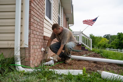 crew installing discharge lines and downspout extensions