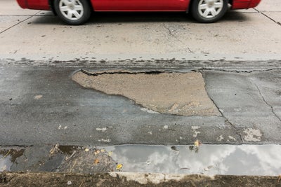 concrete flaking pitting red car