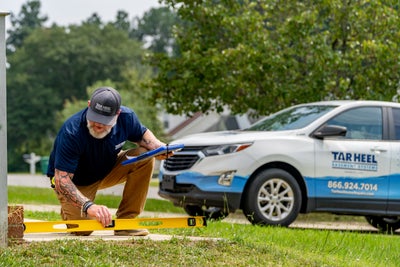 Tar Heel Basement Systems crew member measuring steps work truck