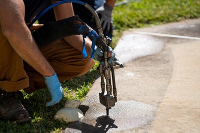 crew installing polyurethane foam under concrete
