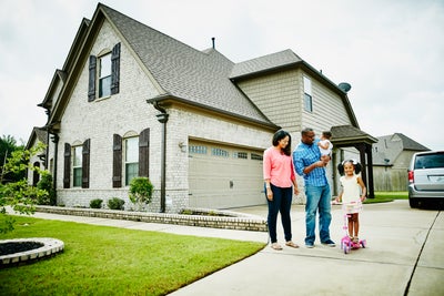 A family standing outside of their new home