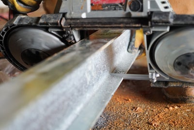 a metal beam being customized before installion