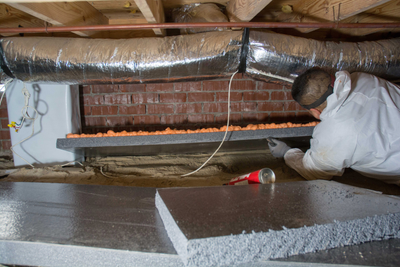 A Groundworks worker in a crawl space excited about resolving the problems.