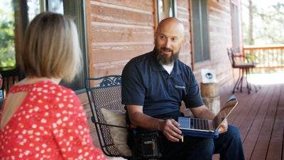 A Groundworks employee showing this homeowner a simple solution for their sinking concrete.