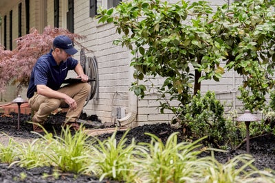 crew member inspecting home perimeter