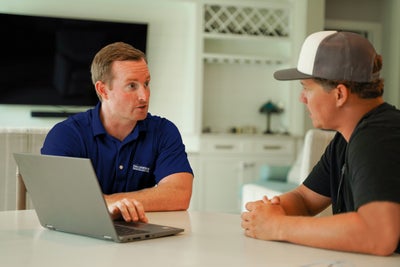 Foundation Recovery Systems team member sitting with customer to discuss how to waterproof a basement