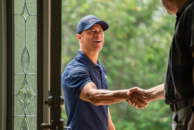 AquaGuard inspector shaking hands with homeowner at front door.