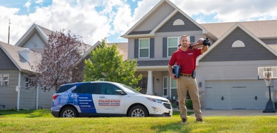 Foundation Recovery Systems CFI in front of home with wrapped car