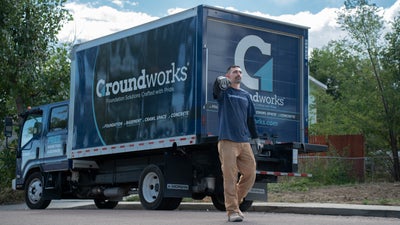 A Groundworks employee next to a Groundworks truck.