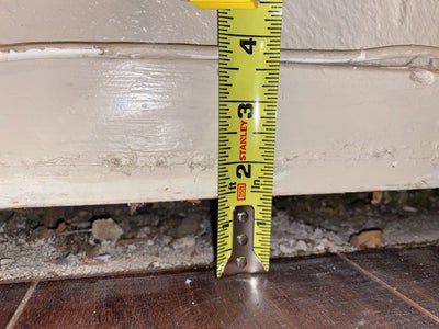 Measuring tape looking at uneven floor.