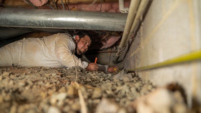 Groundworks employee inspecting foundation wall