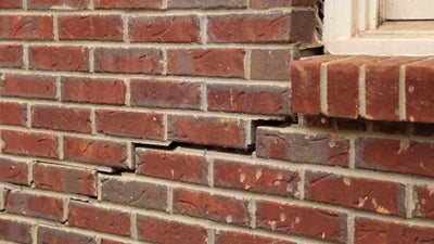 Star-step pattern cracking in brick wall.