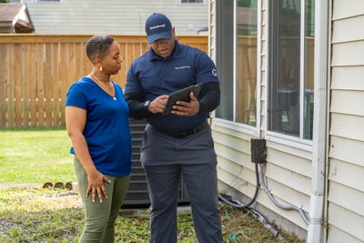 Groundworks inspector talking with homeowner outside a home.