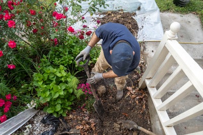 crew member shoveling dirt in flowerbed