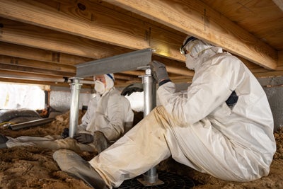 Groundworks professionals installing a custom engineered system made to improve the structure of a crawl space