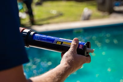 man holding epoxy tube by pool