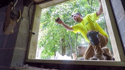 AFS crewman inspecting the door of a crawl space.