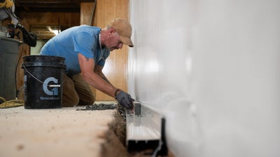 crew installing a basement drain system