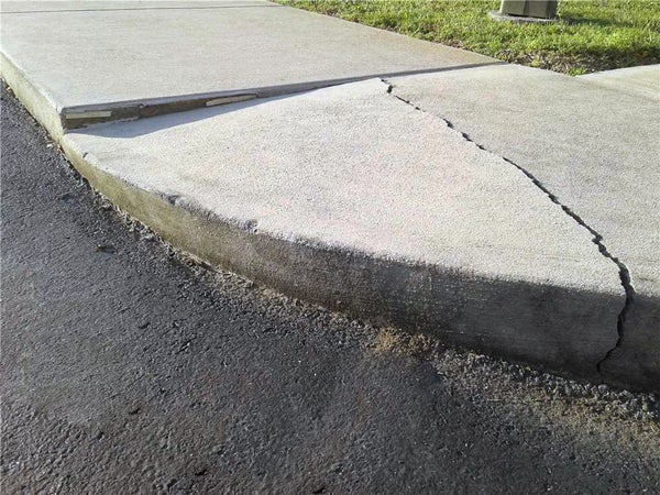 Groundworks tech repairs cracked sideway outside of house