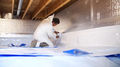 crew taping down crawl space vapor barrier
