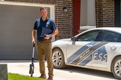 FSS inspector in front of a home.