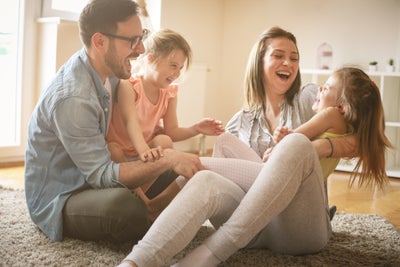 Family playing on the floor in a home.