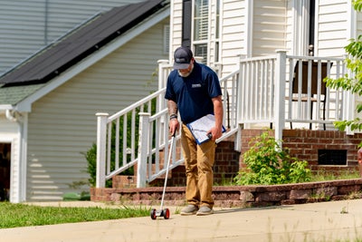 inspector measuring concrete sidewalk