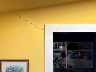 diagonal drywall crack in the corner of a doorway
