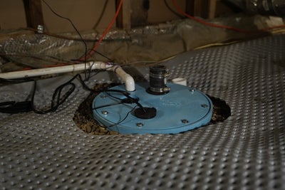 A sump pump in the crawl space of a home