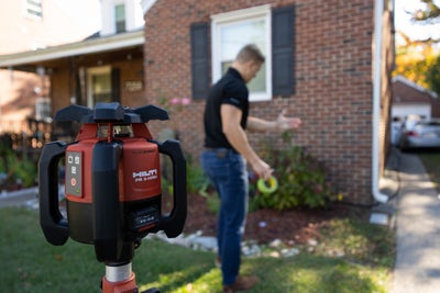 Foundation expert inspecting a home with laser level.