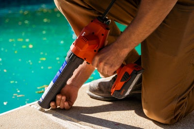 Sealing control joints on a concrete pool deck.