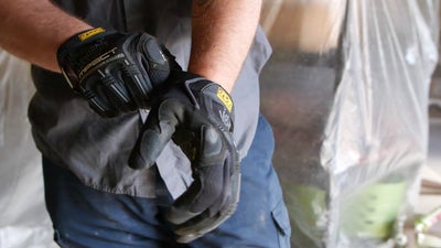 Man putting on work gloves