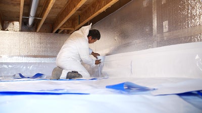 crew installing crawl space insulation and vapor barrier